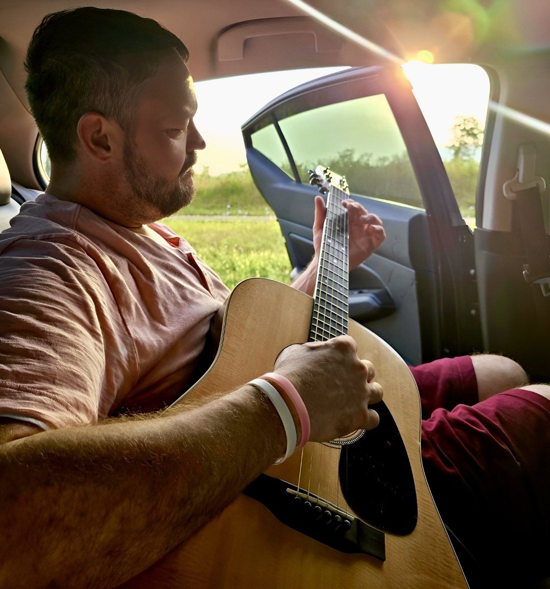 John Leonard playing acoustic guitar in warm evening light
